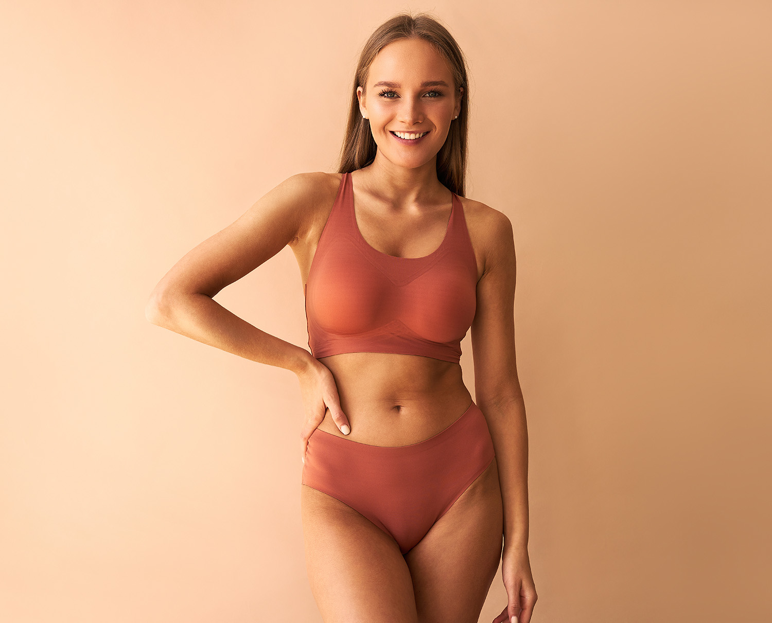 Attractive confident young woman posing on beige background