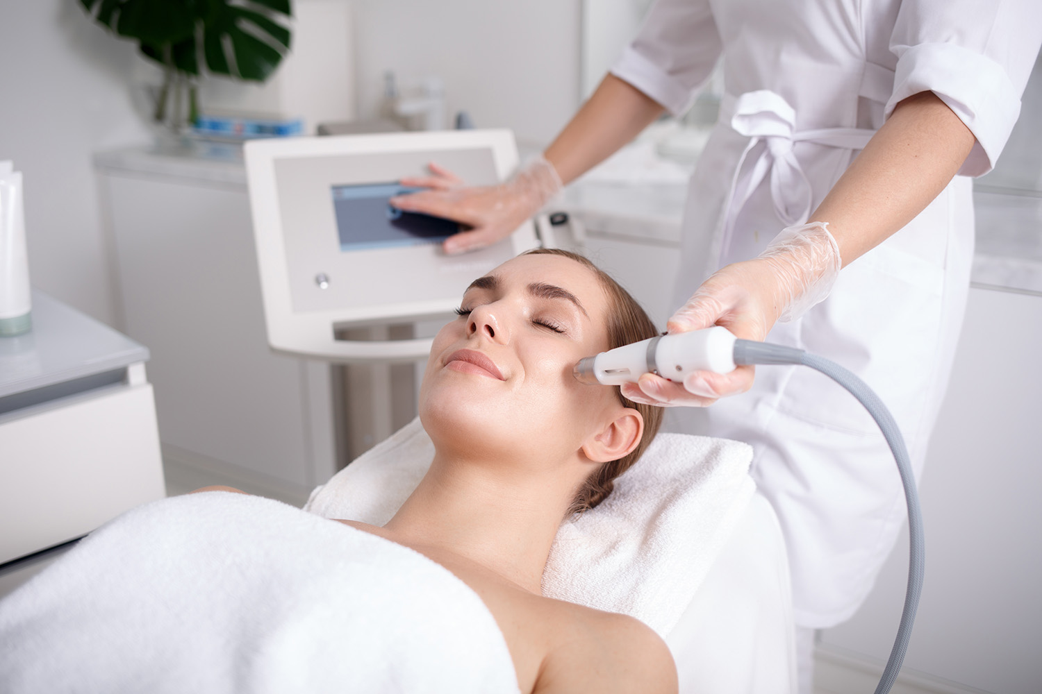 Side view of happy young woman getting cavitation rejuvenating skin treatment at spa