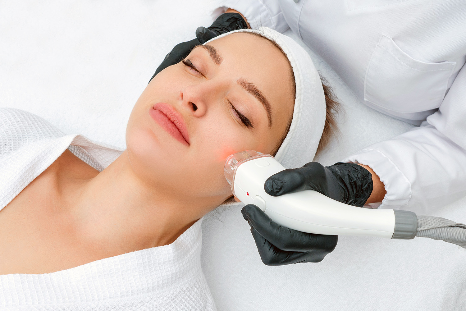 Young woman receiving laser treatment in cosmetology clinic